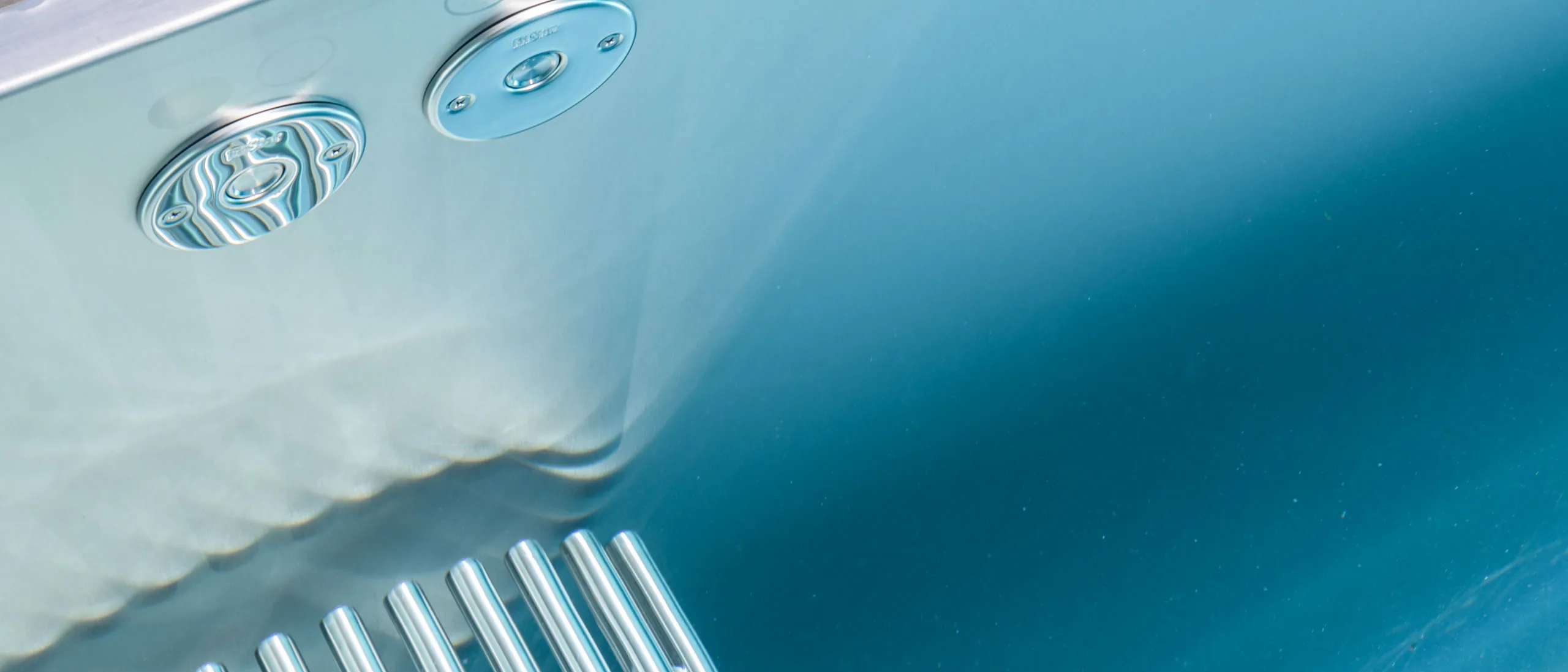 Underwater view of stainless steel inlet jets in a polished pool wall
